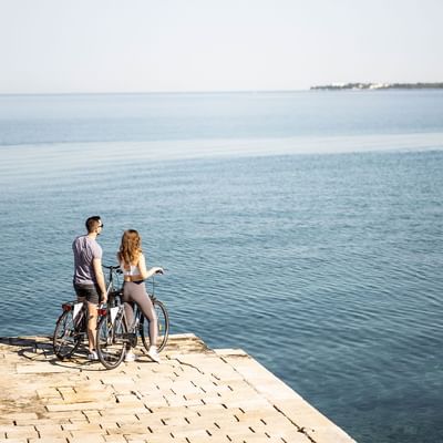 A couple with cycles on a hilltop near Falkensteiner Hotels