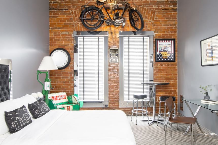 Bedroom with vintage motorbike hung on the brick wall in Queen Premiere Easy Rider at Retro Suites Hotel