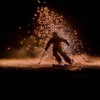 Skifahrer abends auf der Piste mit leuchtenden Effekten beim Show on snow.