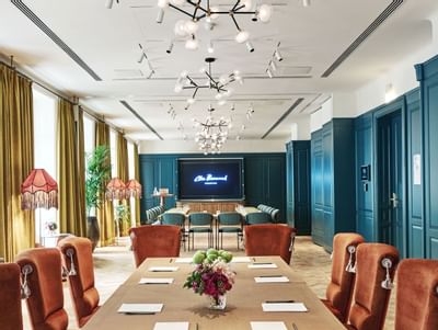 Bel Étage meeting room with a long wooden table, stylish chairs, and decorative lamps at Hotel Motto Vienna