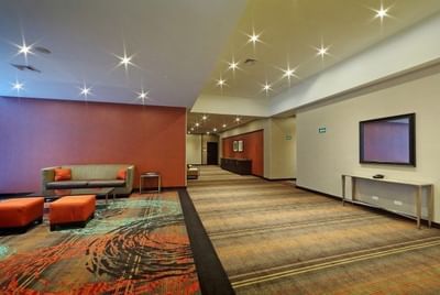 Modern lobby with seating area, carpeted floor and TV at MARlNN Place Financial District, 5 star hotels in Panama