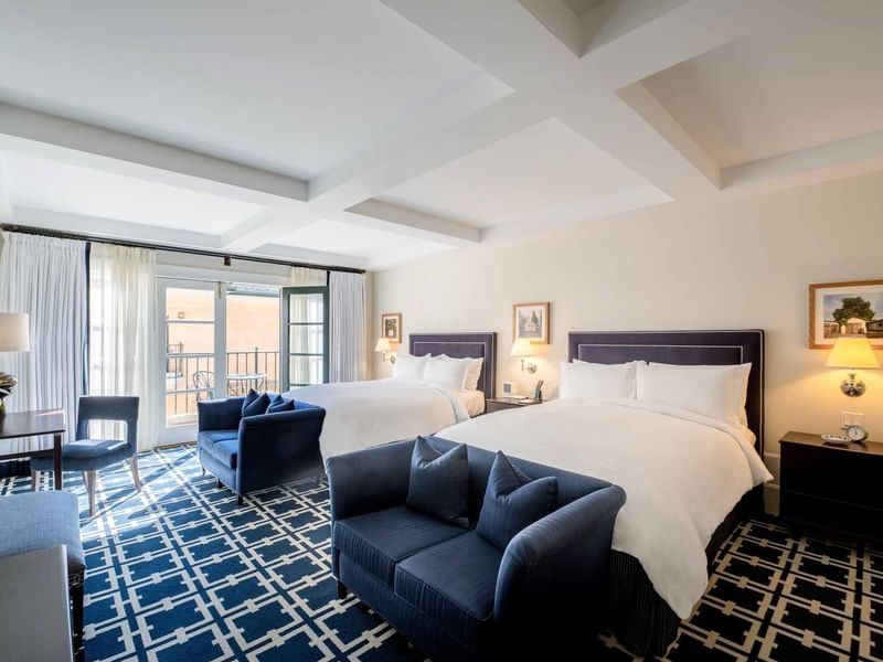 Workspace and two cozy sofas by the beds in Deluxe Queen Queen Room with carpeted flooring at El Prado Hotel