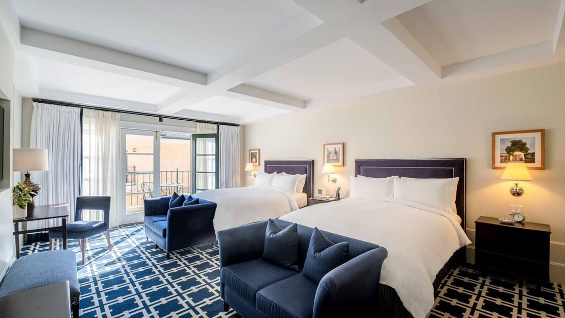 Workspace and two cozy sofas by the beds in Deluxe Queen Queen Room with carpeted flooring at El Prado Hotel