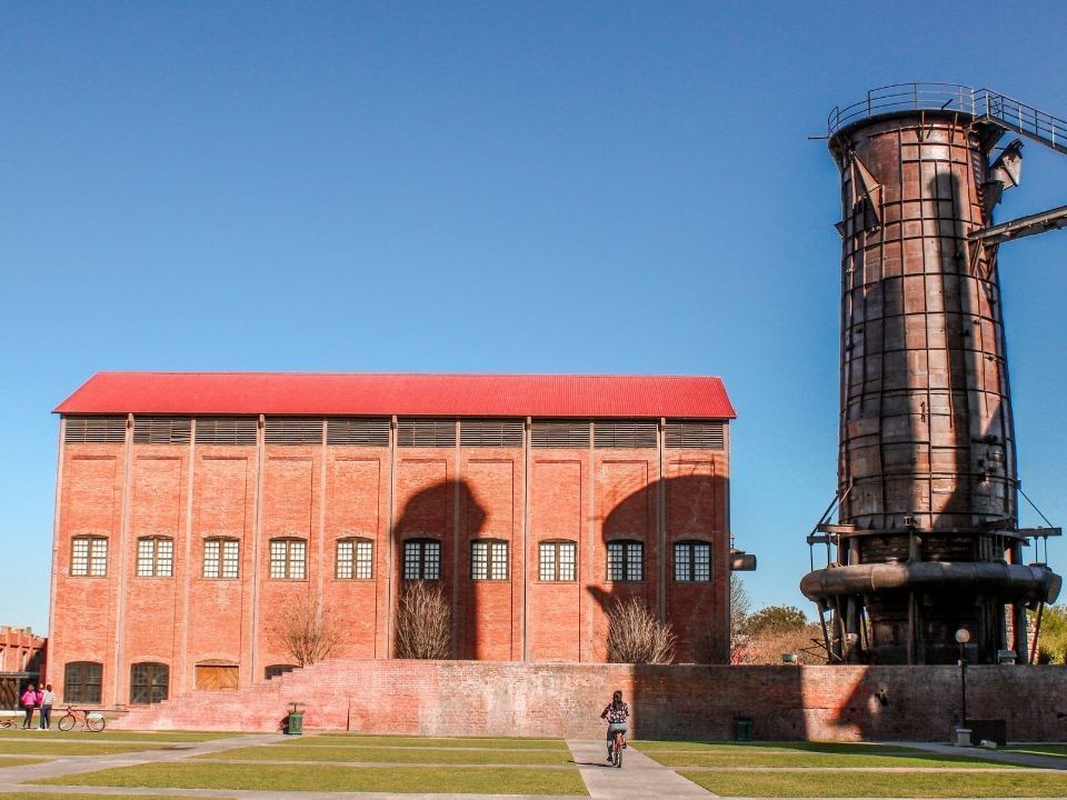 Edificio industrial histórico de ladrillo rojo cerca de Camino Real Hotels, con una torre metálica única