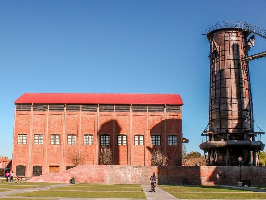 Edificio industrial histórico de ladrillo rojo cerca de Camino Real Hotels, con una torre metálica única