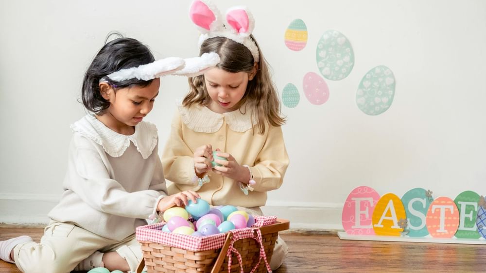 Two children in bunny ears playing with Easter eggs at Novotel Sydney Olympic Park