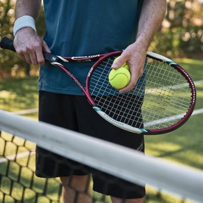 Tennis player holding a racket & a ball, Falkensteiner Hotels