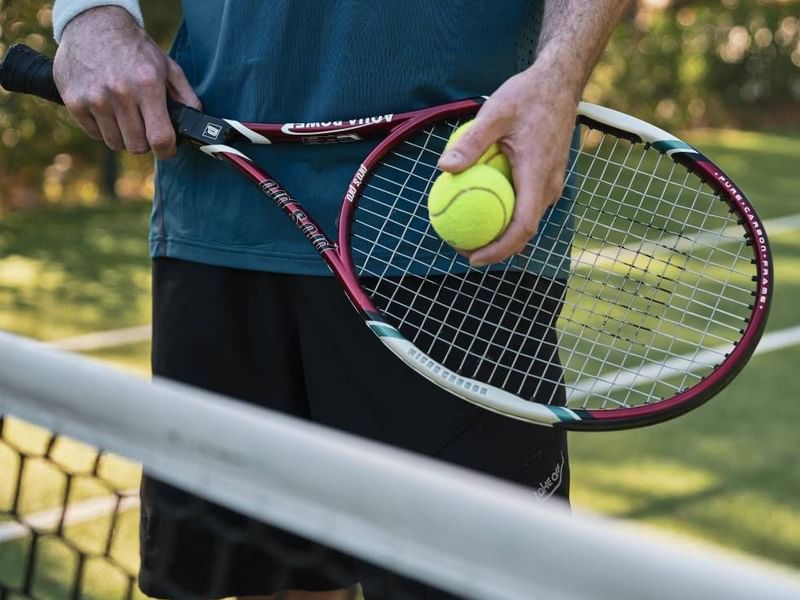 Tennis player holding a racket & a ball, Falkensteiner Hotels