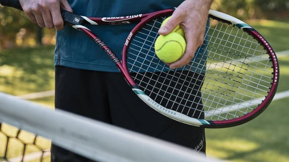 Tennis player holding a racket & a ball, Falkensteiner Hotels