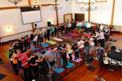 People standing in a room around yoga mats.