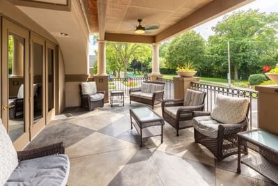 Outdoor seating area on the patio furnished with woven chairs and tables at The Boulevard Inn & Bistro