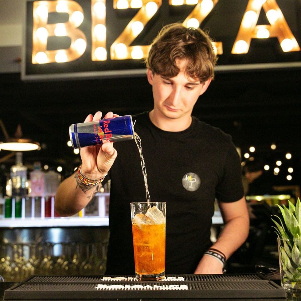 Bartender pouring Red Bull into a mixed drink at bar during Red Bull Guest Night.