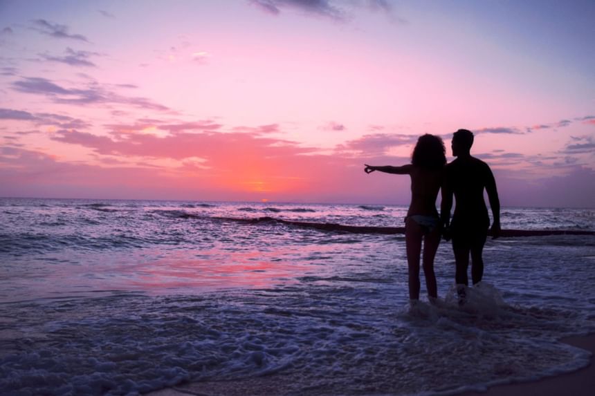 Couple watching the sunset from the shore at Sugar Bay Barbados