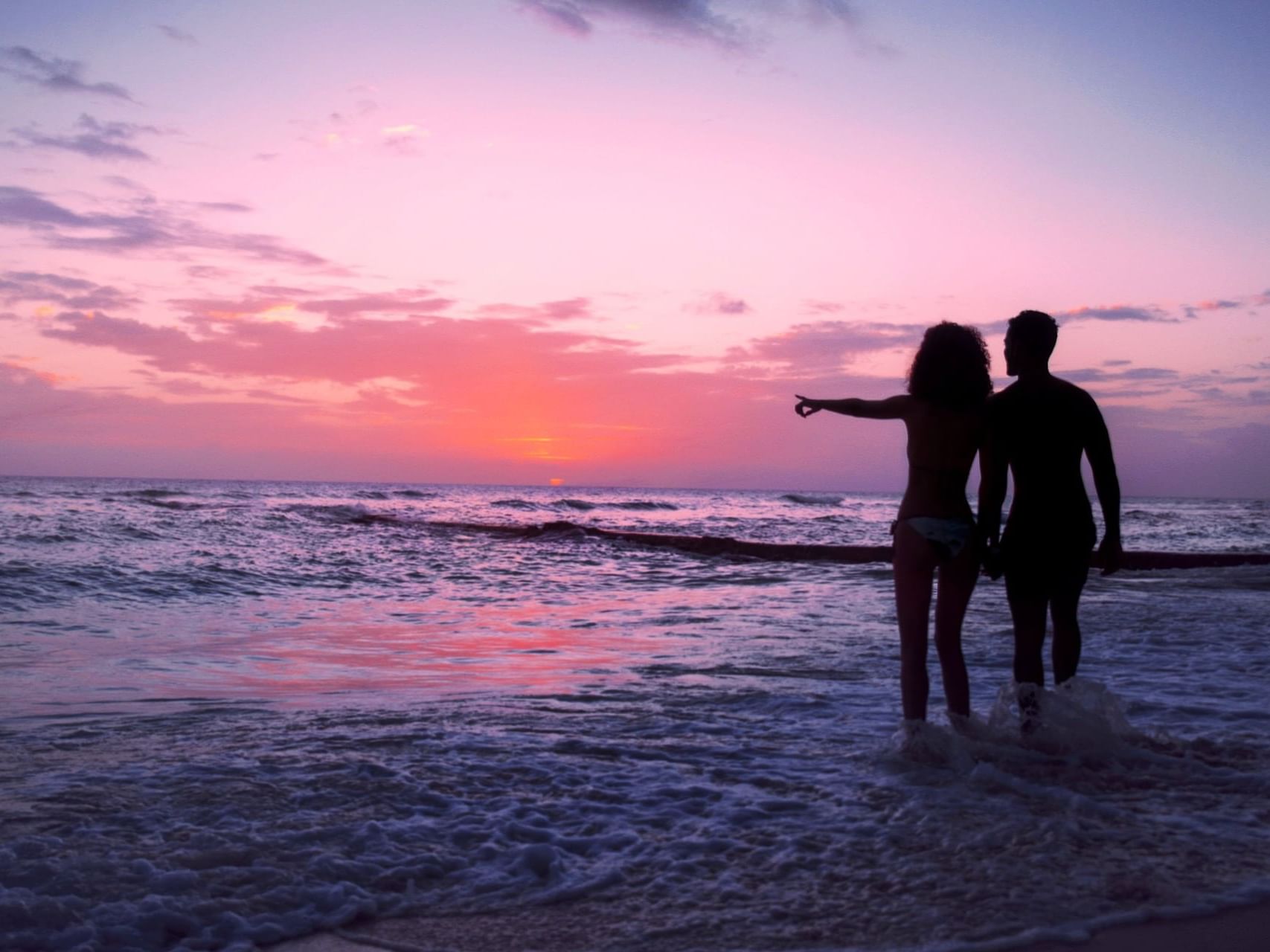 Couple watching the sunset from the shore at Sugar Bay Barbados