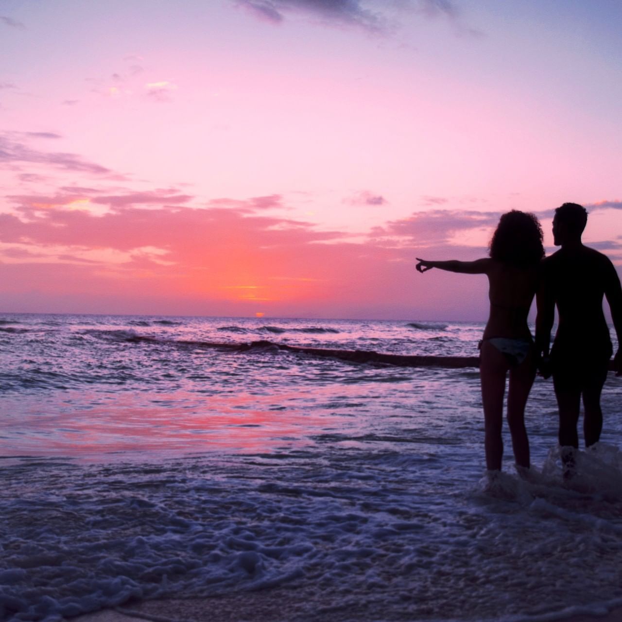 Couple watching the sunset from the shore at Sugar Bay Barbados