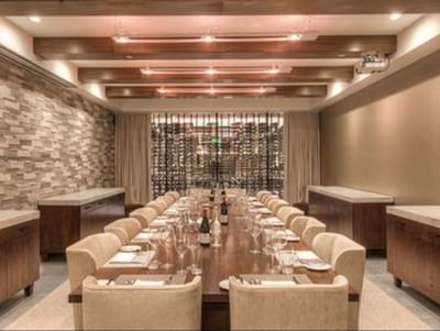 Long dining table in a wine cellar under wood beams in Private Dining Room at The J House Greenwich