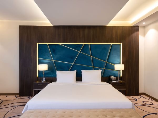 Panoramic Room with cozy bed and lamps at Warwick Riyadh