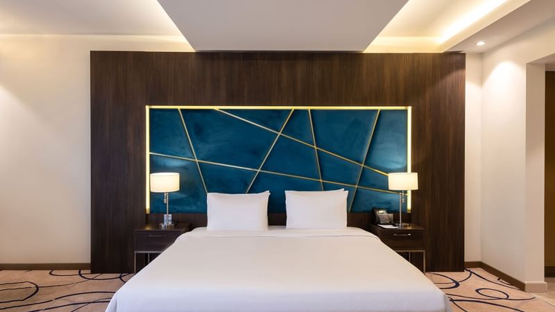 Comfy bed with side table in Panorama Suite at Warwick Riyadh