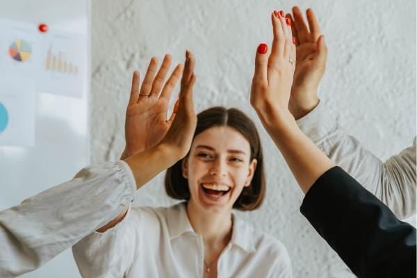 Team at meeting high fiving each other