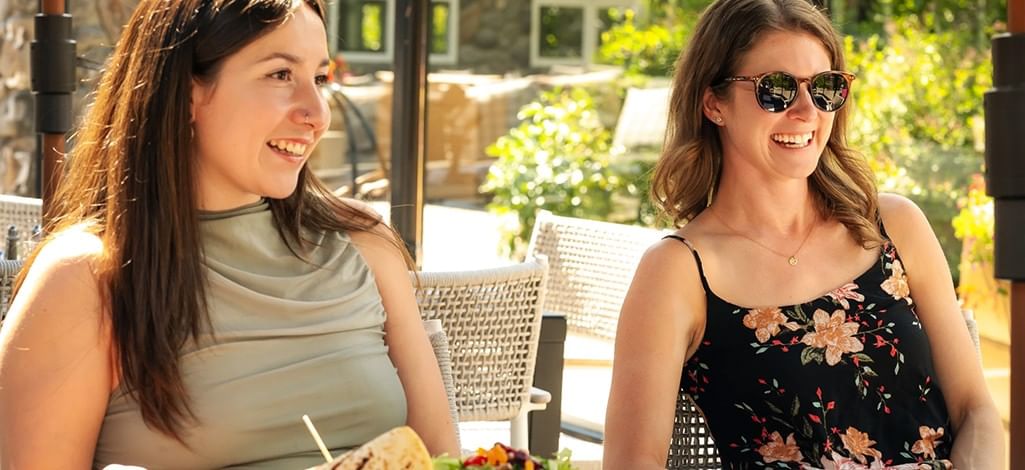 Two people enjoy a meal at a Canmore restaurant on a sunny day, feeling their best.