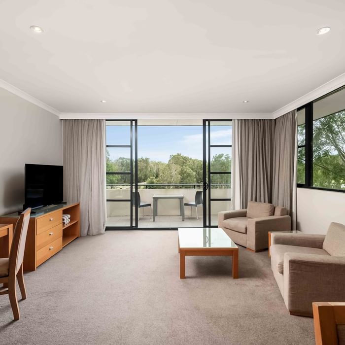 light filled living area with carpet floors and 2 couches