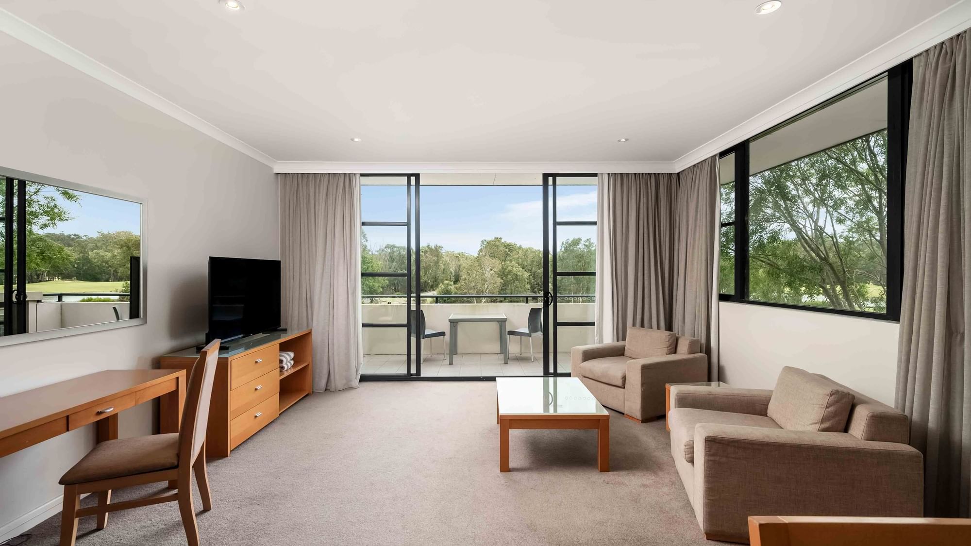 light filled living area with carpet floors and 2 couches