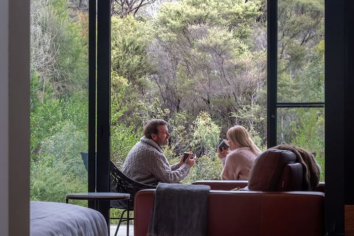 Couple enjoying the view while drinking hot beverages at Freycinet Lodge