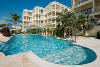 Outdoor pool with view of building of Windsong Resort On The Reef