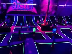 Flying Squirrel Trampoline Park illuminated by vibrant neon lights near Acclaim Hotel Calgary