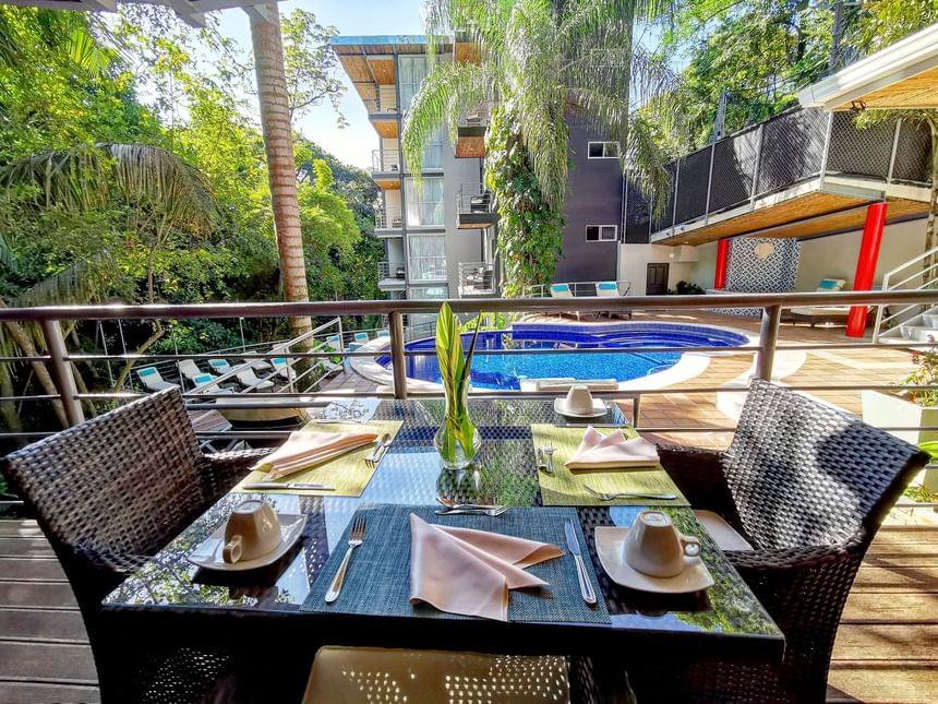 Mesa de comedor junto a la piscina al aire libre en Sloth Snack Bar en Jungle Vista Boutique Hotel