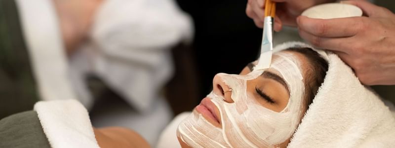 Woman relaxing during a soothing facial treatment at the luxurious Pullman Magenta Shores spa, eyes closed