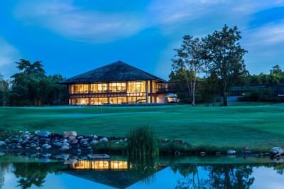 The exterior of Chatrium Golf Resort from the garden at night