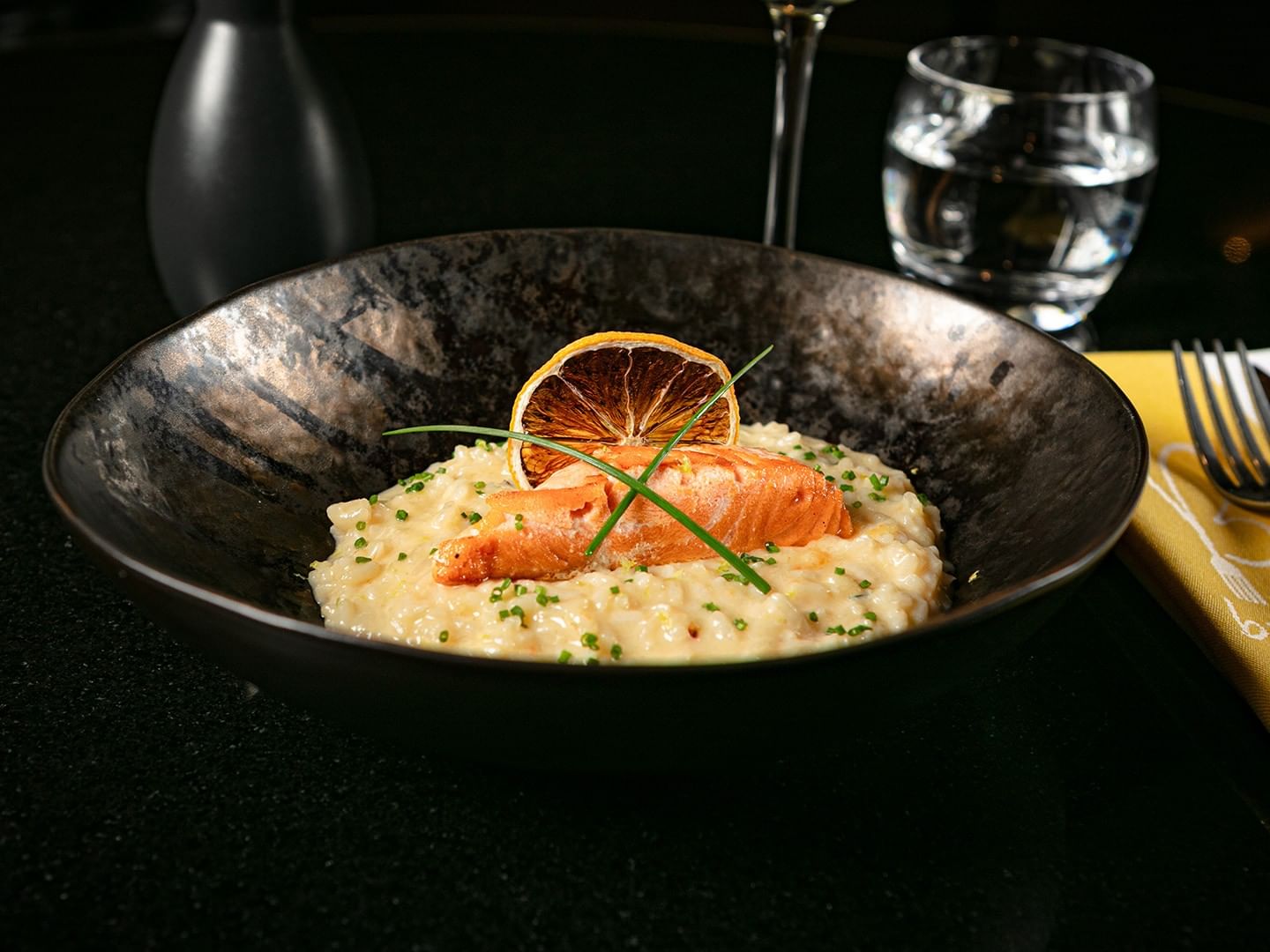 Gourmet salmon risotto served in Bistro elegantly plated in a bowl with a dried lemon slice at Camino Real Polanco Mexico