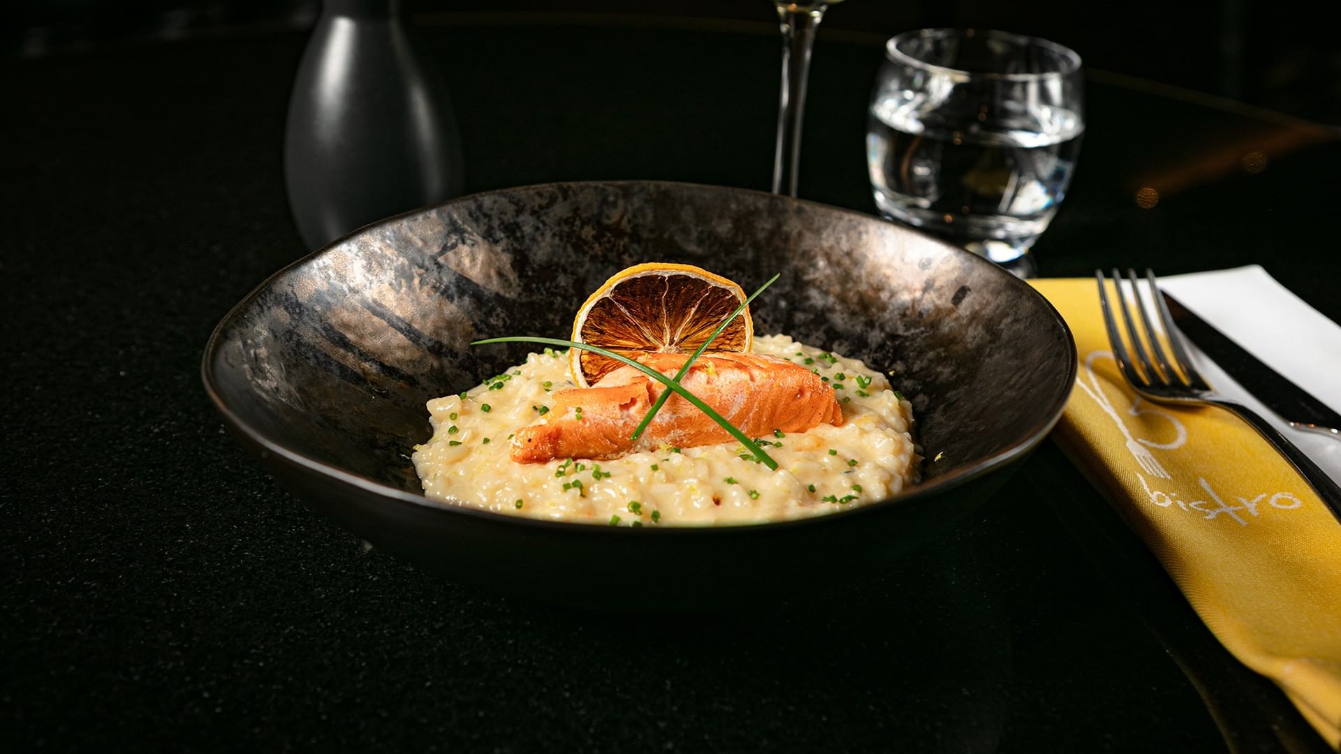 Gourmet salmon risotto served in Bistro elegantly plated in a bowl with a dried lemon slice at Camino Real Polanco Mexico