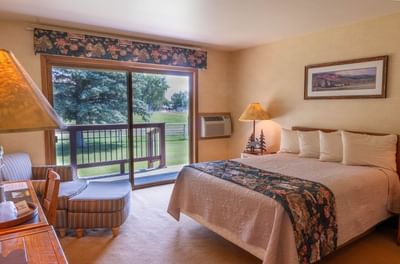Cozy seating area and work desk facing the bed with views of surrounding greenery in The Hunting Lodge at The Ranch at UCross