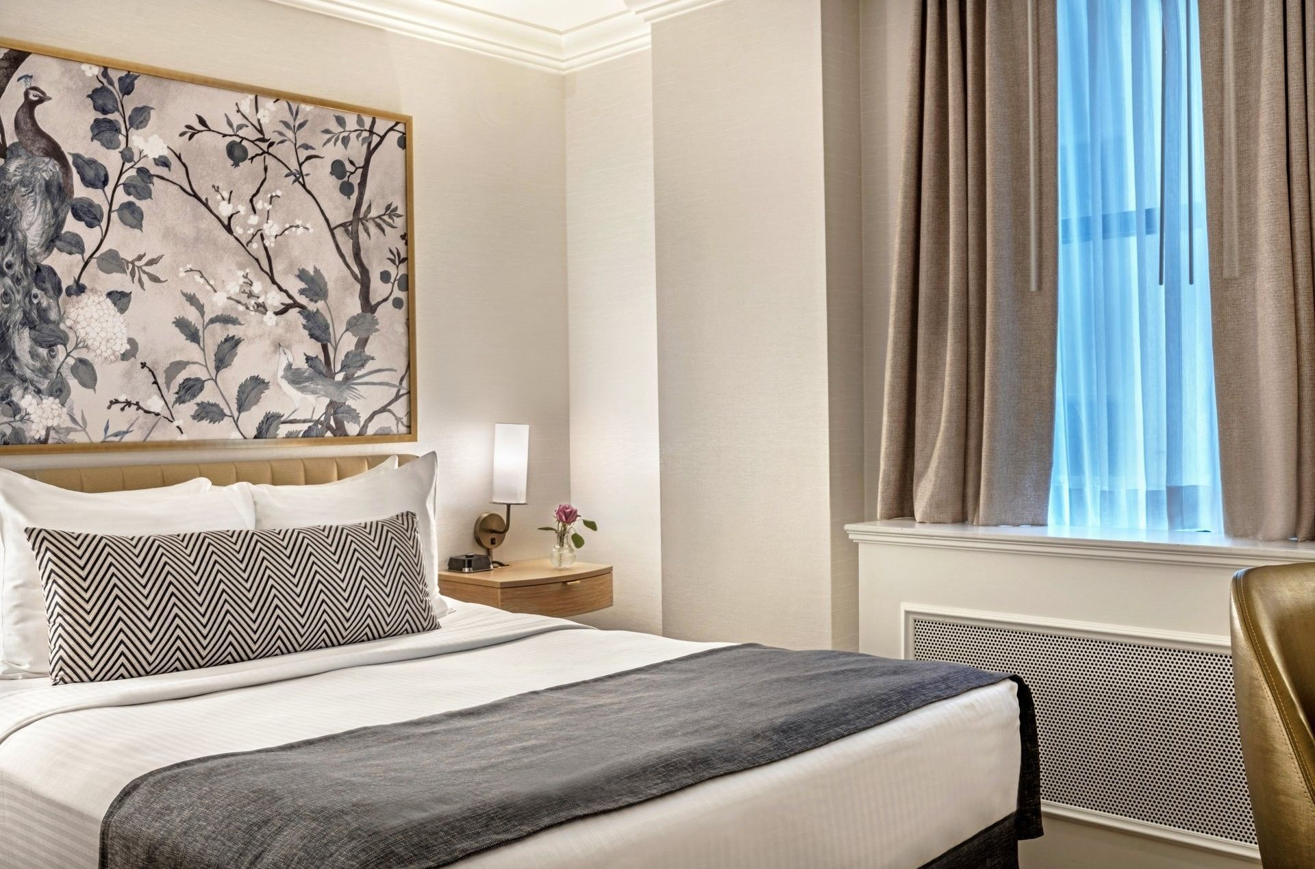 Elegantly decorated hotel room with large bed and floral wall art at Warwick Allerton Chicago Redesign