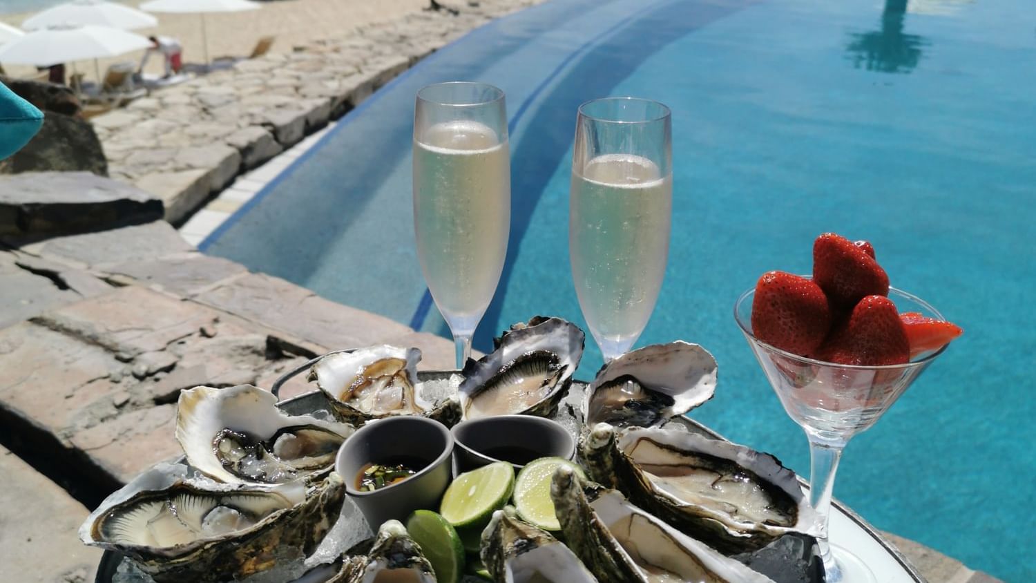 Tray of oysters and champagne by a poolside overlooking the beach in Sirenas Restaurant at Hacienda del Mar Los Cabos.