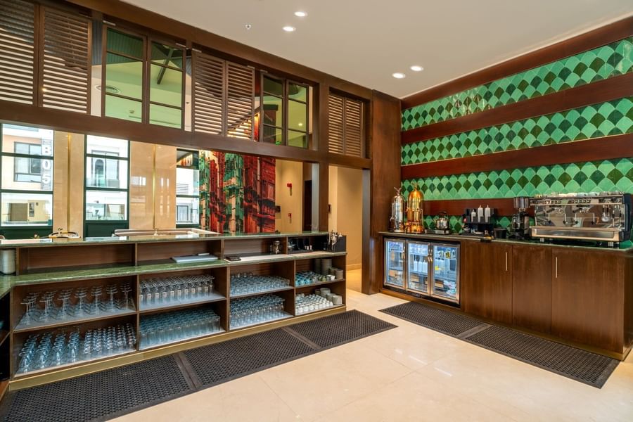 Beverage counter with shelves in Lobby Café at Naviti by Warwick Jeddah, offering fine dining at a Boutique Hotel in Jeddah