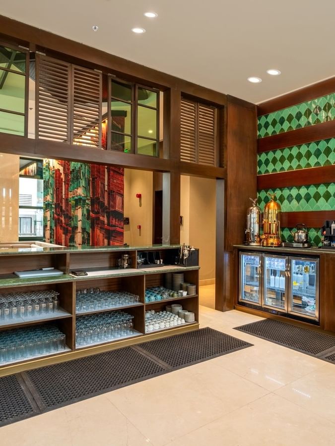 Beverage counter with shelves in Lobby Café at Naviti by Warwick Jeddah, offering fine dining at a Boutique Hotel in Jeddah