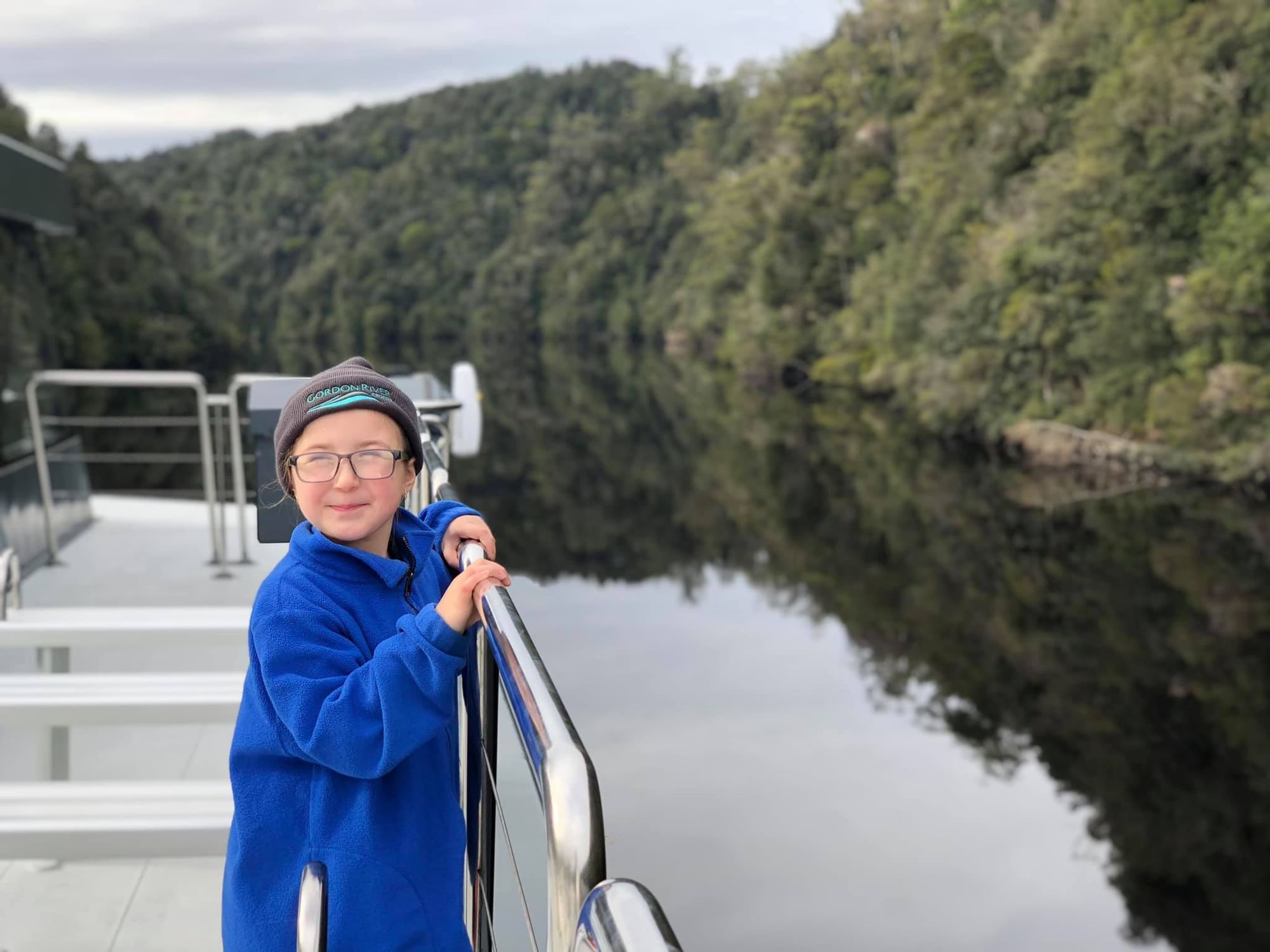 A Kid leaning on the cruise railing at Gordon River Cruise