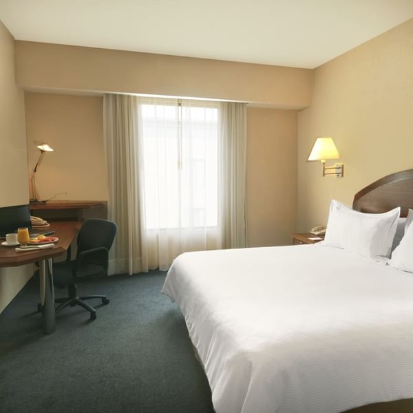 King bed with working desk In Superior Room at Fiesta Inn