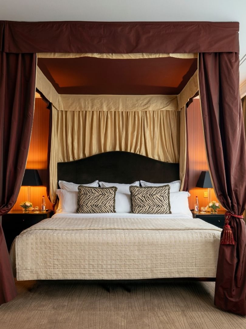 Une chambre élégante avec un lit à baldaquin et une décoration raffinée au Warwick Champs-Élysées à Paris.