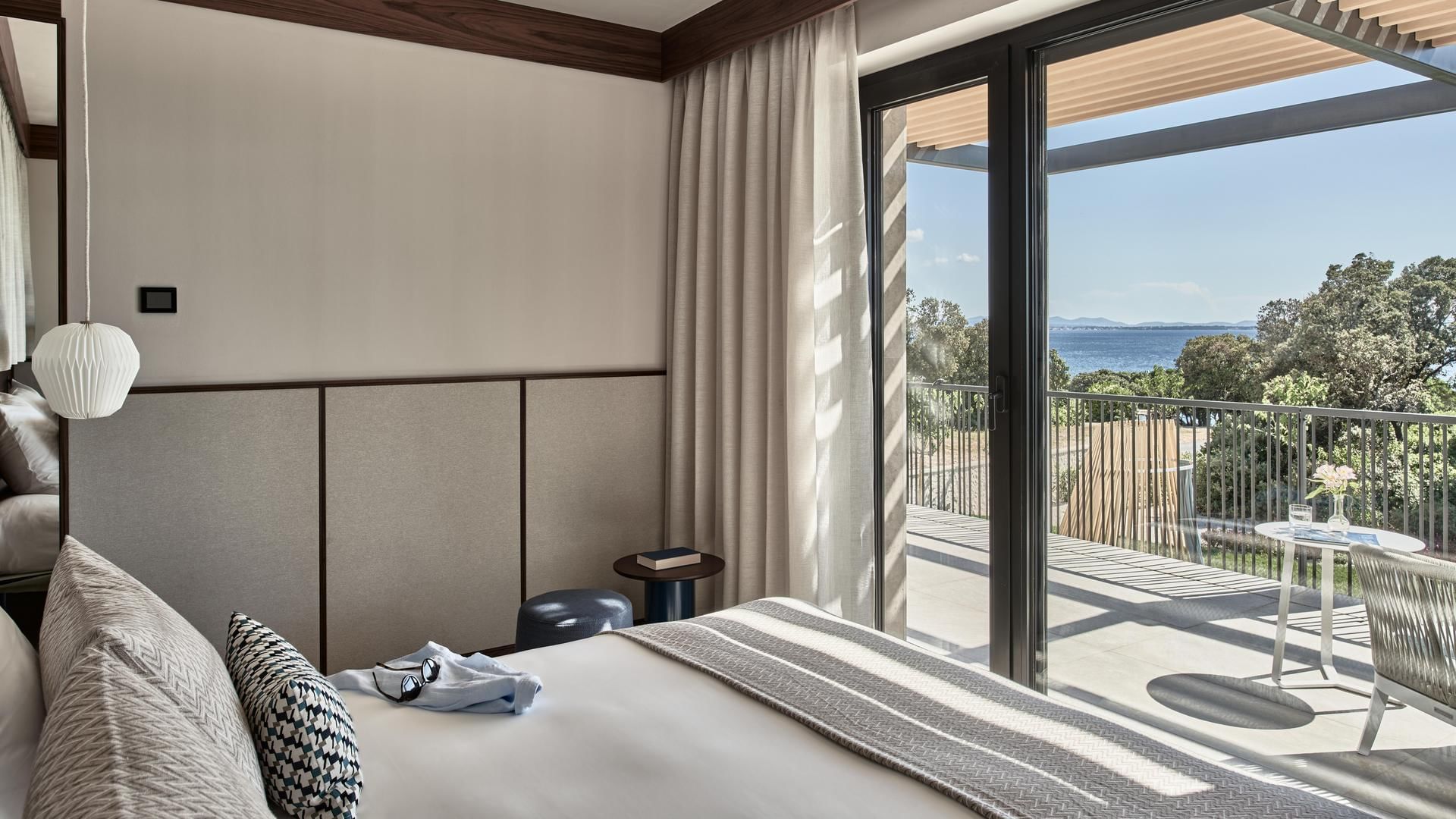 Bedroom with sliding door leading to a terrace overlooking the sea in Villa Anastasia at Falkensteiner Resort Punta Skala
