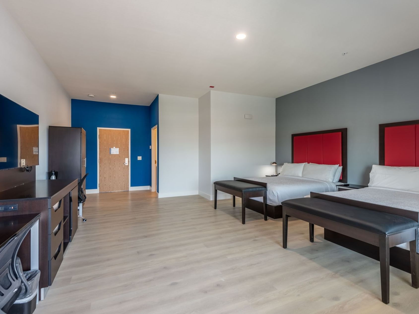 TV and side cupboard facing the beds in Two Bedroom Suite with wooden floors at The J Hotel, one of the top Dunedin hotels