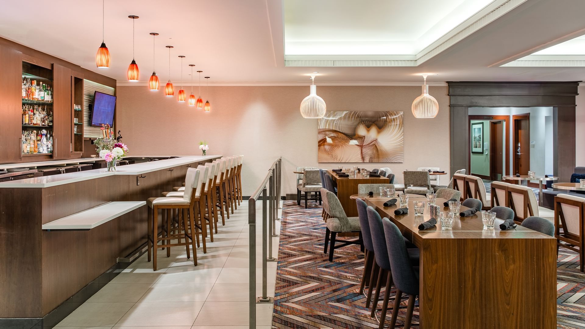 A dining area with a bar, tables, and chairs.