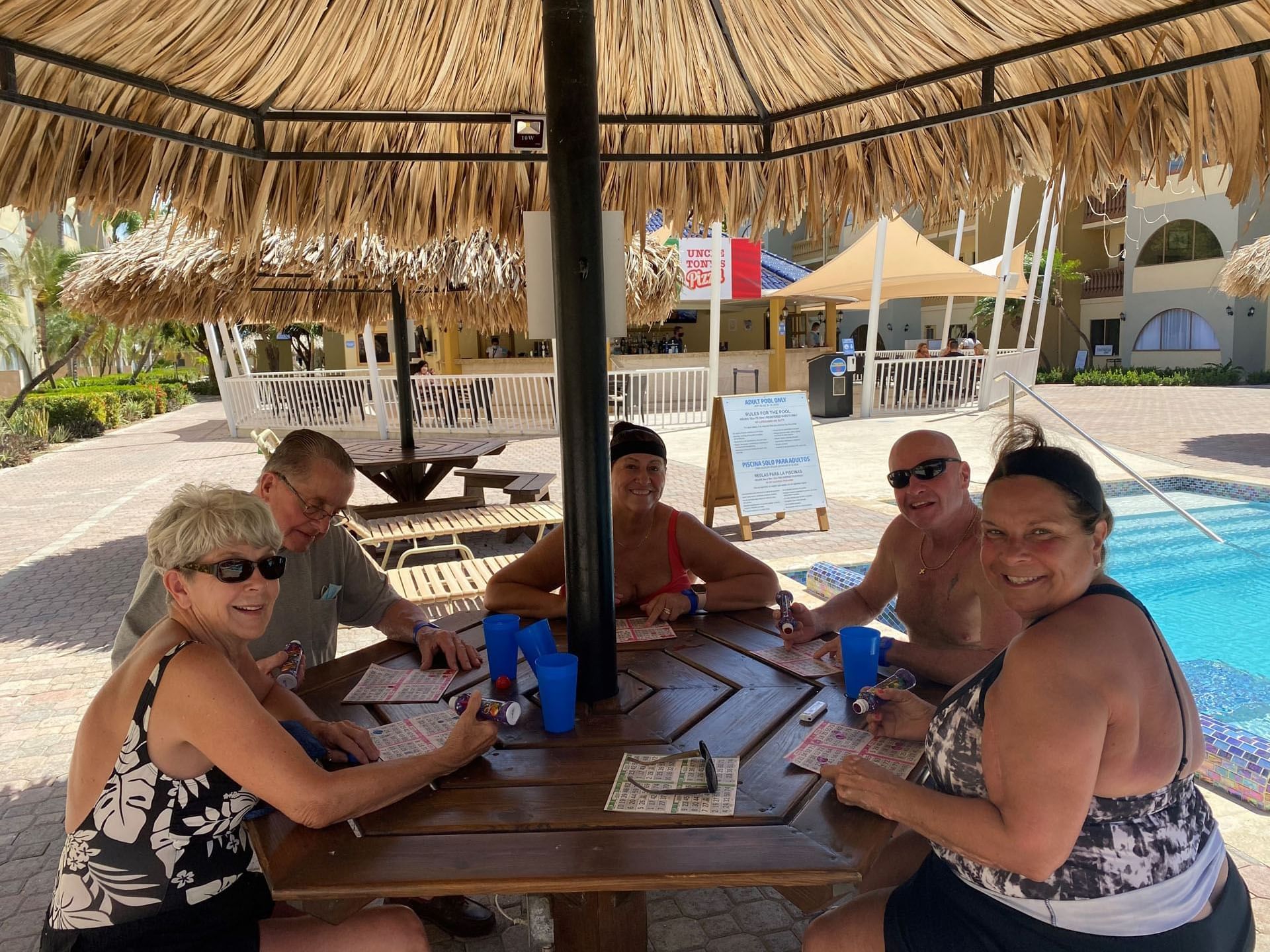 People on a dining table by the pool at Eagle Aruba Resort