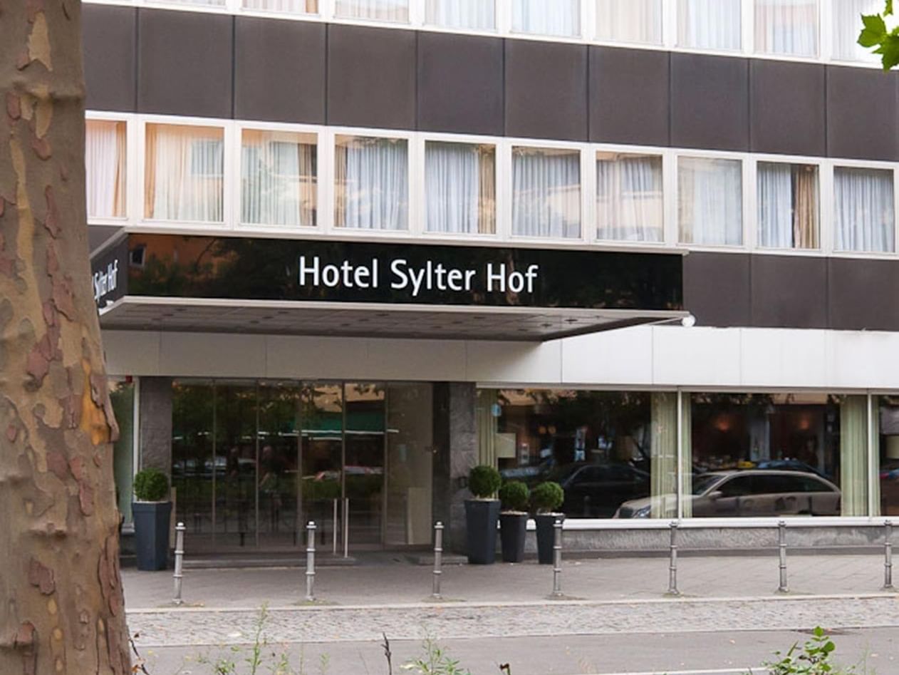Modern hotel exterior with glass entrance at Sylter Hof Berlin.