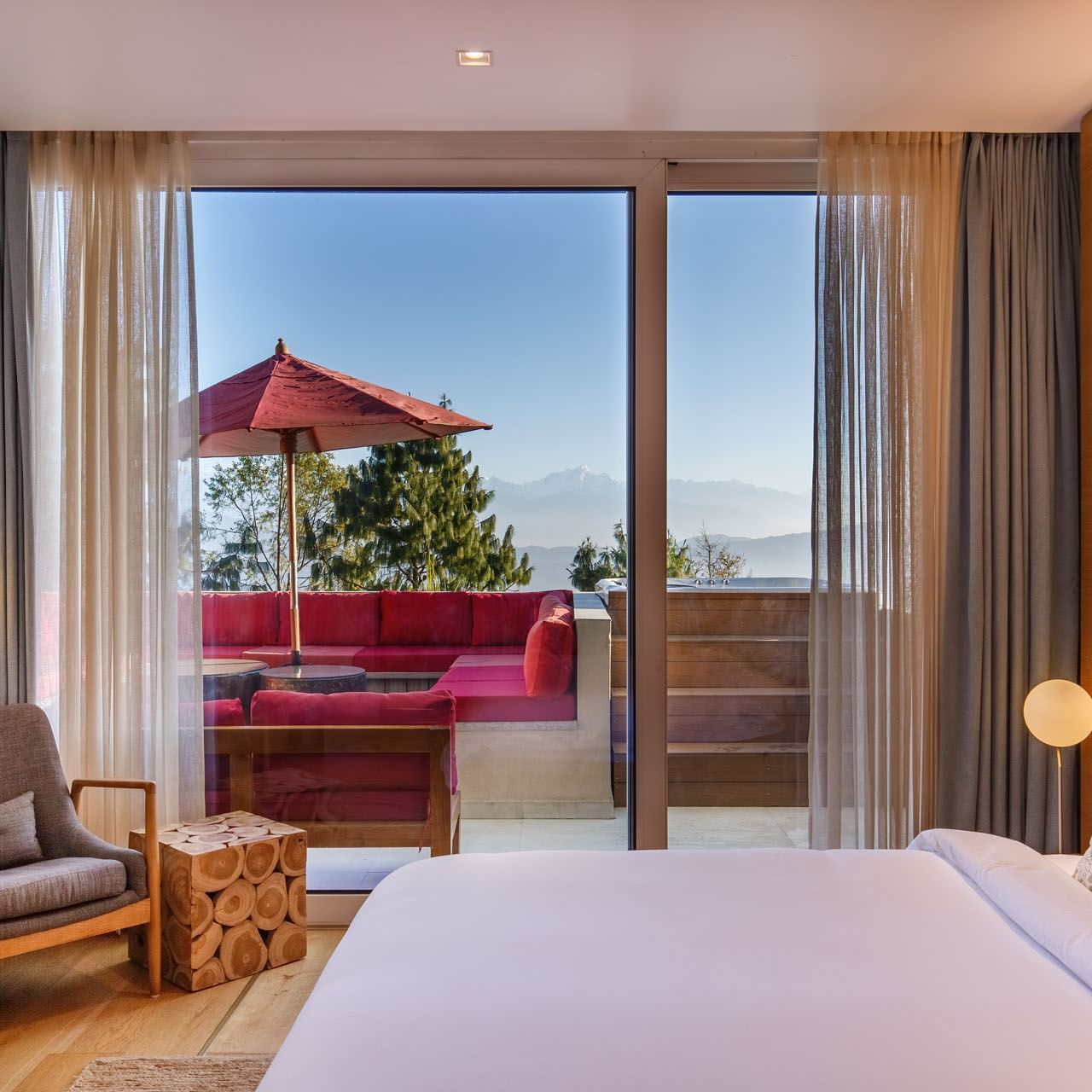 Bed and large window overlooking mountains, and wooden accents in superior suite at The Terraces Resort & Spa