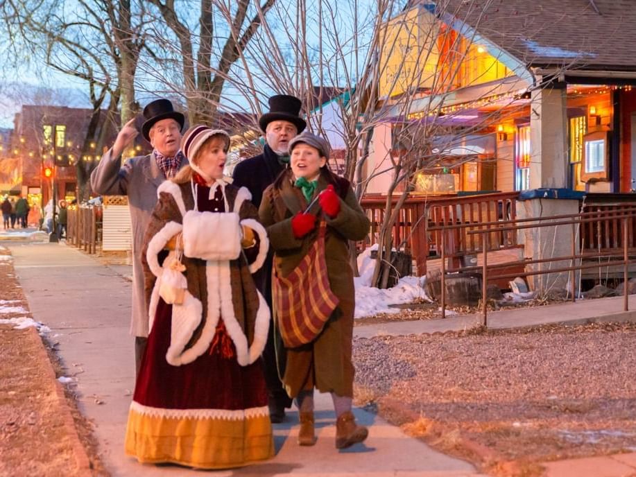 People singing carols on the road near Kinship Landing