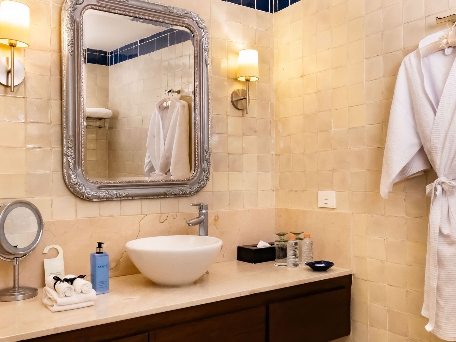 Baño elegante con espejo, lavabo, toallas y albornoz en Suite Gran Clase King en Quinta Real Puebla, Heroica Puebla de Zaragoza